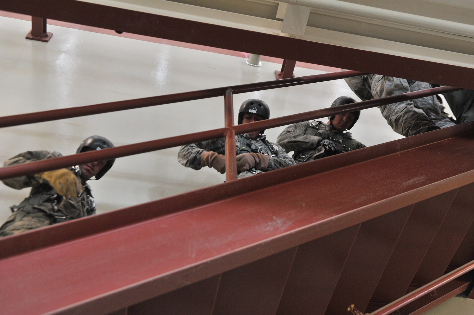 Students attending the Survival, Evasion, Resistance and Escape school walk to the second floor of the parachute training center and prepare to practice static line rappelling at Fairchild Air Force Base, Washington, June 27, 2014.  The 22nd Training Squadron parachute training tests, evaluates, demonstrates and instructs emergency egress parachute systems for Air Force aircrew career fields. (U.S. Air Force photo by Staff Sgt. Alexandre Montes/Released)