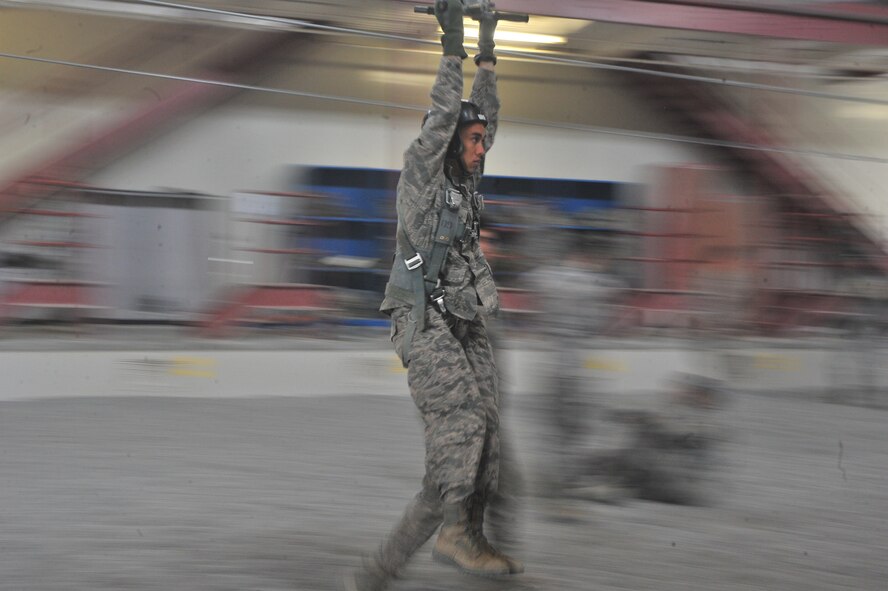 A student attending the Survival, Evasion, Resistance and Escape school moves down the zip line to practice landing safety during parachute training at Fairchild Air Force Base, Washington, June 27, 2014.  The 22nd Training Squadron parachute training tests, evaluates, demonstrates and instructs emergency egress parachute systems for Air Force aircrew career fields. (U.S. Air Force photo by Staff Sgt. Alexandre Montes/Released)