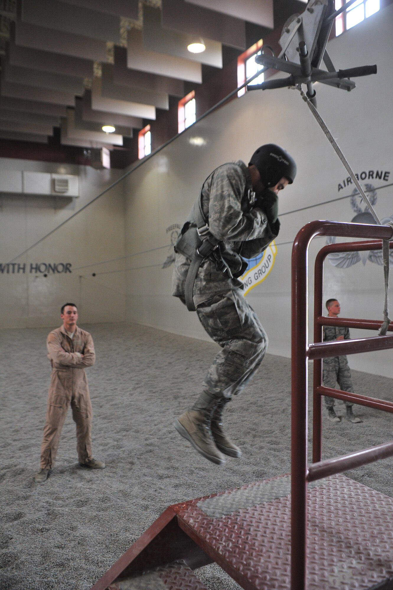 Staff Sgt. Jared Biller, 22nd Training Squadron Survival, Evasion, Resistance and Escape specialist, watches a student’s landing technique during parachute landing safety at Fairchild Air Force Base, Washington, June 27, 2014.  The 22nd TRS parachute training tests, evaluates, demonstrates, and instructs emergency egress parachute systems for Air Force aircrew career fields. (U.S. Air Force photo by Staff Sgt. Alexandre Montes/Released)