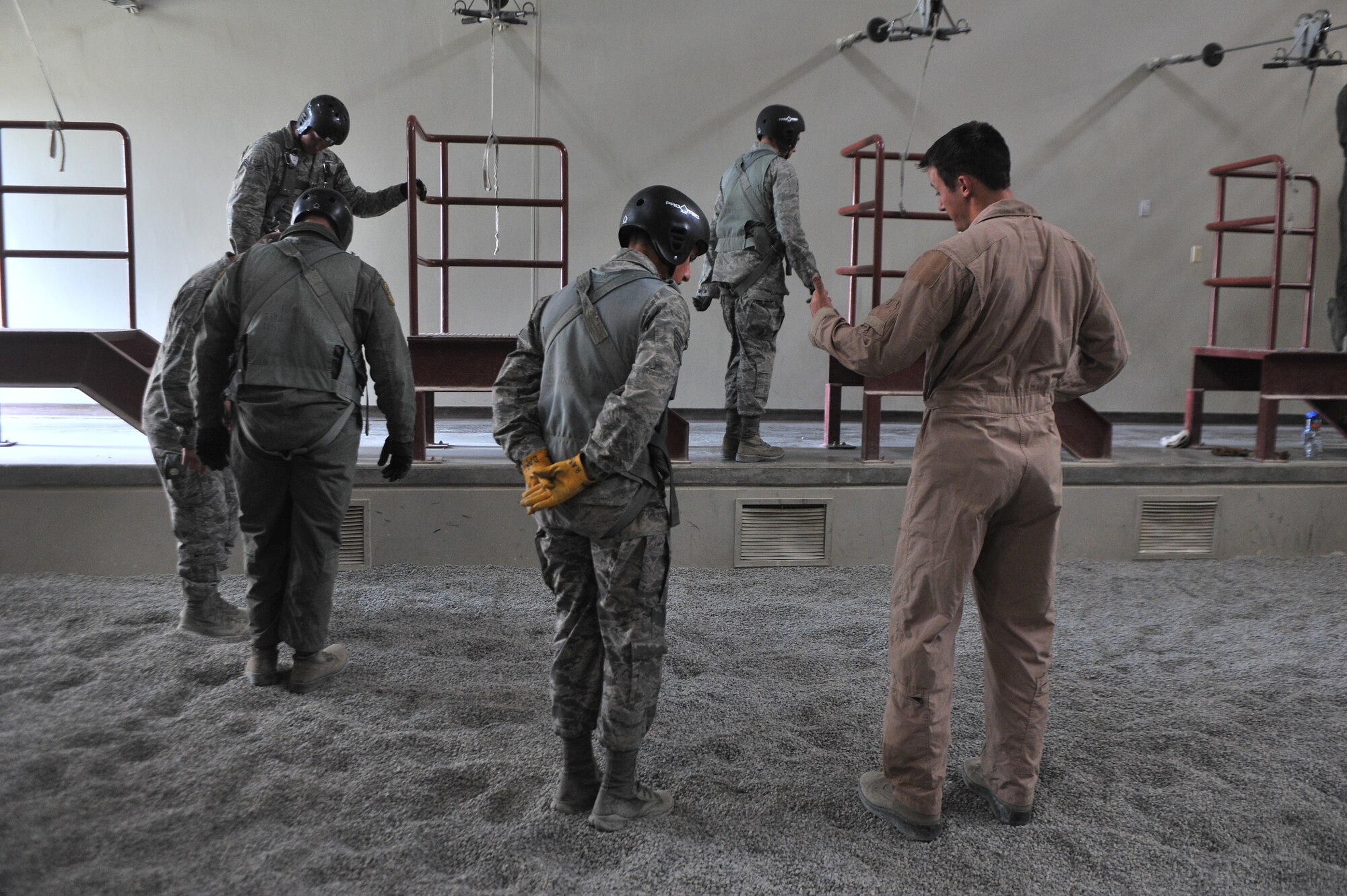 Staff Sgt. Jared Biller, 22nd Training Squadron Survival, Evasion, Resistance and Escape specialist, instructs a student on proper landing during parachute landing safety at Fairchild Air Force Base, Washington, June 27, 2014.  The 22nd TRS parachute training tests, evaluates, demonstrates and instructs emergency egress parachute systems for Air Force aircrew career fields. (U.S. Air Force photo by Staff Sgt. Alexandre Montes/Released)