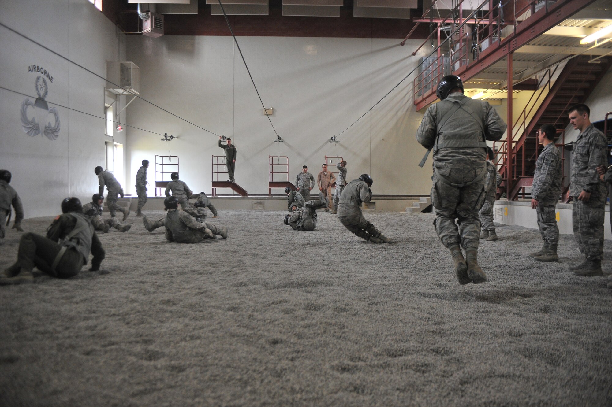 Students attending the Survival, Evasion, Resistance and Escape school practice their parachute landing safety skills at Fairchild Air Force Base, Washington, June 27, 2014.  The 22nd Training Squadron parachute training tests, evaluates, demonstrates and instructs emergency egress parachute systems for Air Force aircrew career fields. (U.S. Air Force photo by Staff Sgt. Alexandre Montes/Released)