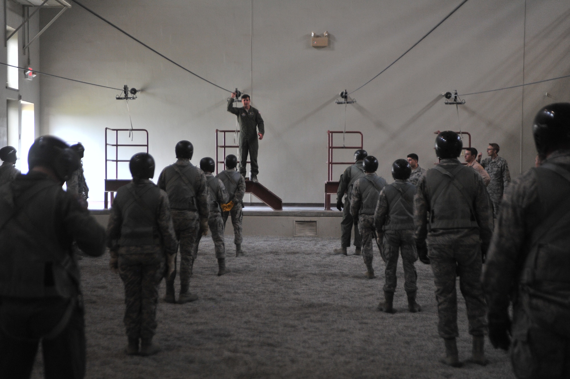 Students attending the Survival, Evasion, Resistance and Escape school listen to Staff Sgt. Steven Kincheleo, 22nd Training Squadron Survival, Evasion, Resistance and Escape specialist, about parachute landing safety at Fairchild Air Force Base, Washington, June 27, 2014.  The 22nd TRS parachute training tests, evaluates, demonstrates and instructs emergency egress parachute systems for Air Force aircrew career fields. (U.S. Air Force photo by Staff Sgt. Alexandre Montes/Released)