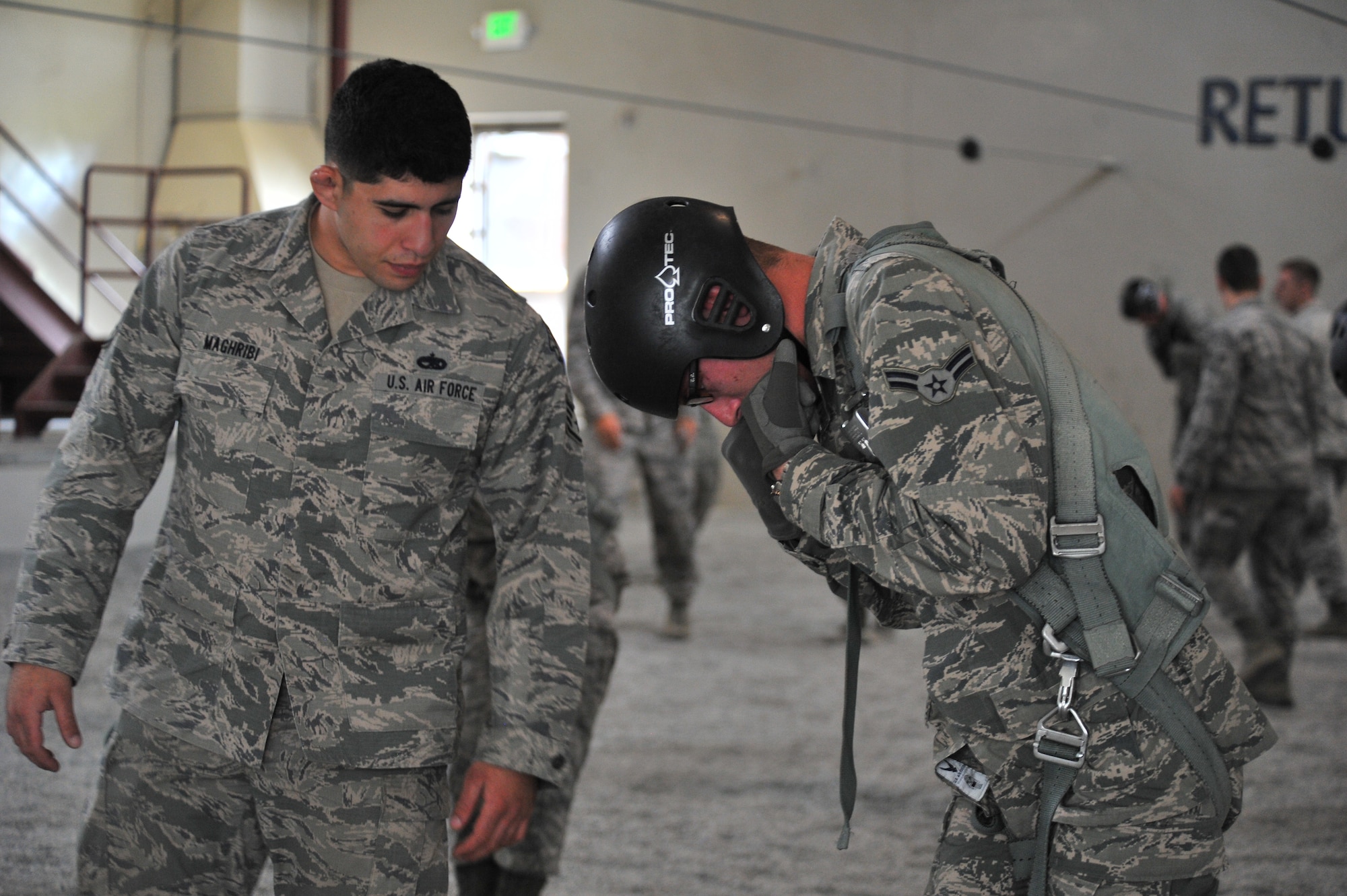Staff Sgt. Nader Maghribi, 22nd Training Squadron Survival, Evasion, Resistance and Escape specialist, instructs a student on proper foot and knee placement during parachute landing safety at Fairchild Air Force Base, Washington, June 27, 2014.  The 22nd TRS parachute training tests, evaluates, demonstrates and instructs emergency egress parachute systems for Air Force aircrew career fields. (U.S. Air Force photo by Staff Sgt. Alexandre Montes/Released)