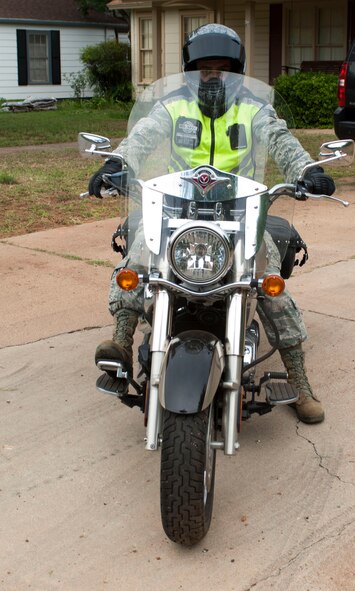 U.S. Air Force Staff Sgt. Saul Arvizu, 7th Civil Engineer Squadron, prepares to ride his motorcycle June 11, 2014, in Abilene, Texas. Arvizu ensures he has his protective riding gear including his reflective vest to stay visible, a Department of Transportation compliant helmet and gloves to protect his hands. (U.S. Air Force photo by Airman 1st Class Kylsee Wisseman/Released) 