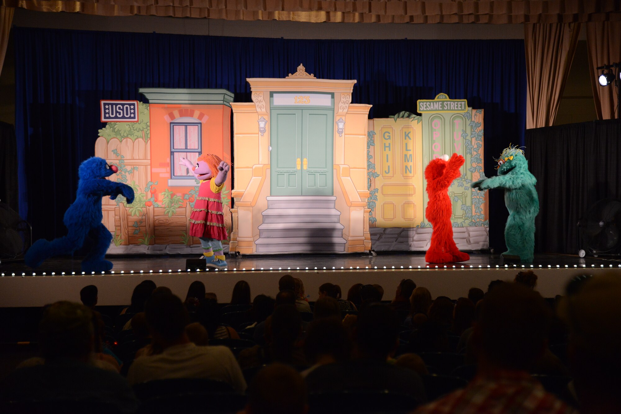 PETERSON AIR FORCE BASE, Colo. – Grover, Katie, Elmo and Rosita dance and sing during the Sesame Street USO experience for military families at the base auditorium June 28. The show is about Katie, a military child and Muppet, who is moving from Sesame Street to a new base. Through song and dance, the rest of the Muppets show her that moving is not so bad. (U.S. Air Force photo/Tech. Sgt. Jared Marquis)