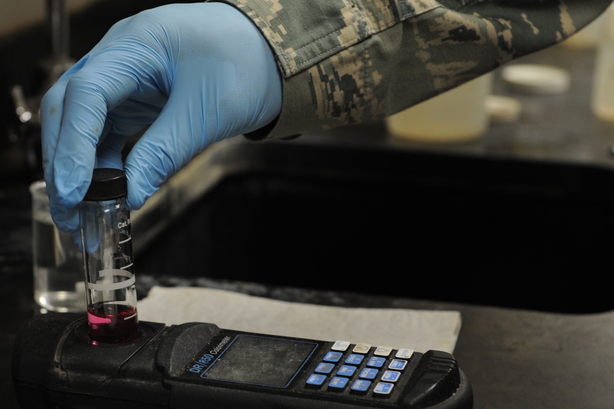 Chief Master Sgt. Wesley Mathias, 375th Air Mobility Wing command chief, tests a sample of water at the waste water treatment plant to ensure it is useable at Scott Air Force Base, Ill. on June 23, 2014. The plant cleans and treats waste water and the base reuses it to irrigate the golf course and other base locations. (U.S. Air Force photo by Senior Airman Sarah Hall-Kirchner/Released)