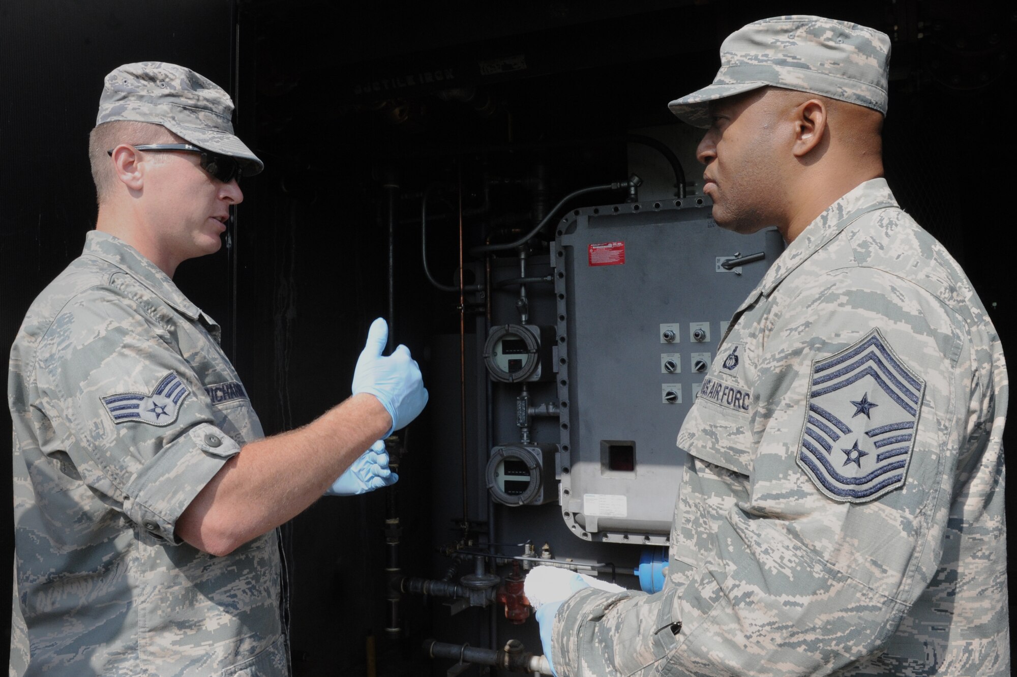 Chief Master Sgt. Wesley Mathias, 375th Air Mobility Wing command chief, discusses how the waste water treatment plant works with Senior Airman Bryan Richardson, 375th Civil Engineer Sqaudron water and fuels systems maintenance journeyman, at Scott Air Force Base, Ill. on June 23, 2014. The plant treats waste water and the base reuses it to irrigate the golf course and other base locations. (U.S. Air Force photo by Senior Airman Sarah Hall-Kirchner/Released)