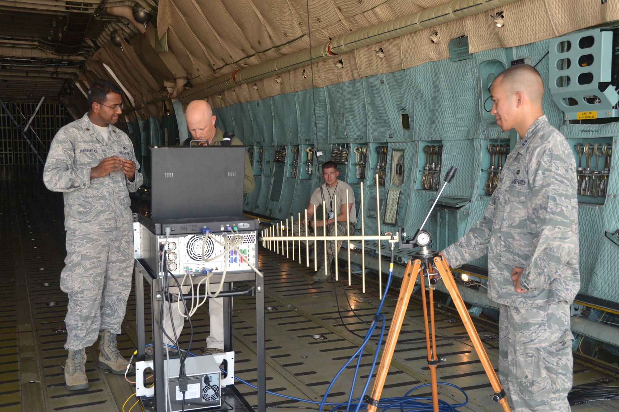 Capt. Henry Bushey (right), 346th Test Squadron emissions security flight commander, Joint Base San Antonio-Lackland, Texas, adjusts an antenna to help the members in the Mobile Assessment Vehicle obtain a decent image of EM signals inside the cargo bay of a C-5A Galaxy aircraft,. The demo provided near-field assessment of the equipment.  The test squadron used one of the 433rd Airlift Wing’s C-5A aircraft on July 26, 2014. 