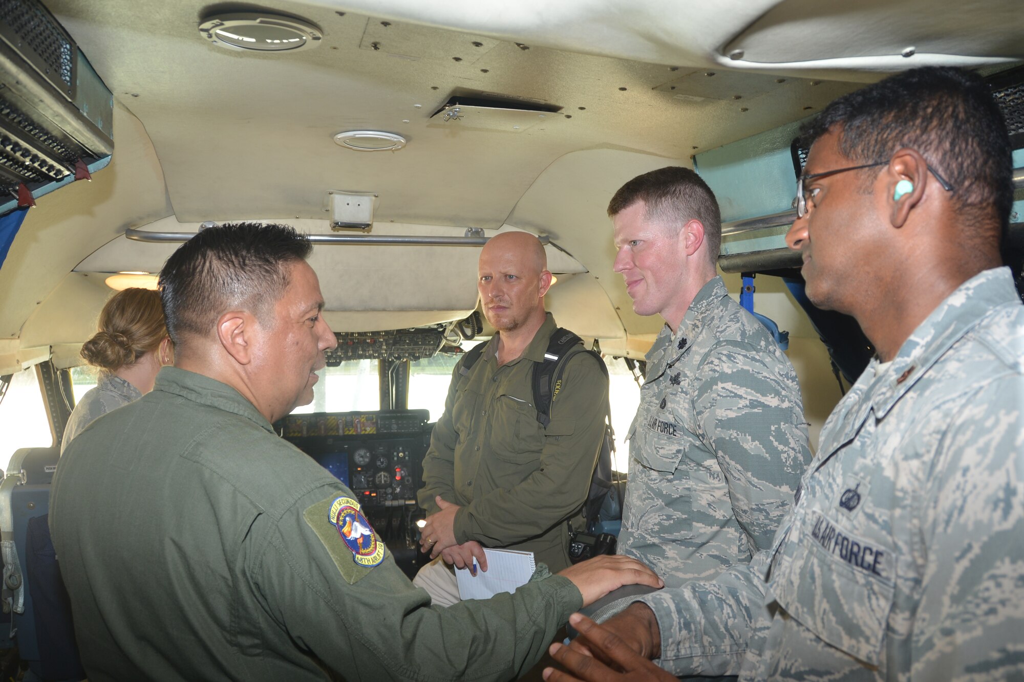 Tech. Sgt. Antonio Rodriguez (left, forefront) a flight engineer from the 68th Airlift Squadron, Joint Base San Antonio-Lackland, Texas talks with members from the 346th Test Squadron and Daniel Terdiman, senior writer from C-NET News about the glass cockpit that features electronic instrument displays and the capabilities of the C5-A Galaxy aircraft. 