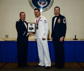 Petty Officer 3rd Class Charles T. Brasel, Naval Health Clinic Charleston hospital corpsman, receives the John T. Levitow award June 26, 2014, at the Airmen Leadership School Class 14-E graduation ceremony at Joint Base Charleston, S.C. The Levitow award is given for a student's exemplary demonstration of excellence, both as a leader and a scholar. (U.S. Air Force photo/ Senior Airman Dennis Sloan) 