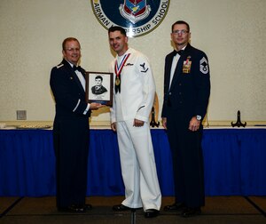 Petty Officer 3rd Class Charles T. Brasel, Naval Health Clinic Charleston hospital corpsman, receives the John T. Levitow award June 26, 2014, at the Airmen Leadership School Class 14-E graduation ceremony at Joint Base Charleston, S.C. The Levitow award is given for a student's exemplary demonstration of excellence, both as a leader and a scholar. (U.S. Air Force photo/ Senior Airman Dennis Sloan) 