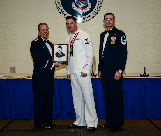 Petty Officer 3rd Class Charles T. Brasel, Naval Health Clinic Charleston hospital corpsman, receives the John T. Levitow award June 26, 2014, at the Airmen Leadership School Class 14-E graduation ceremony at Joint Base Charleston, S.C. The Levitow award is given for a student's exemplary demonstration of excellence, both as a leader and a scholar. (U.S. Air Force photo/ Senior Airman Dennis Sloan) 