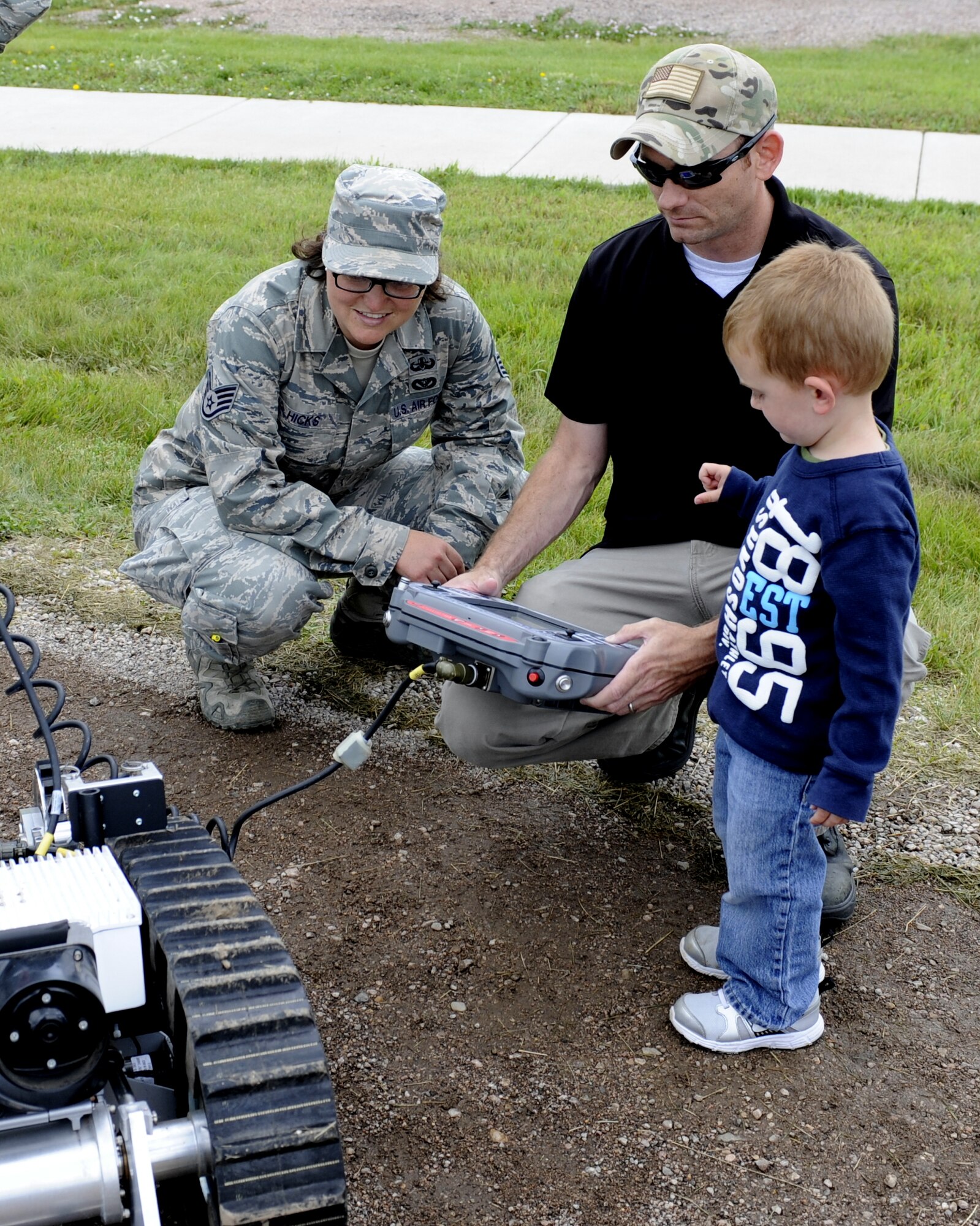 Staff Sgt. Danee Hicks, 28th Civil Engineer Squadron explosive ordnance disposal journeyman, observes Staff Sgt. Nathan Warren, 28th Security Forces Squadron armory NCO in charge, maneuver an HD-1 Air Force Medium Size Robot at the South Dakota Air and Space Museum, S.D., June 28, 2014. Warren and his son Farley joined more than 2,100 visitors from across the country to recognize Ellsworth Heritage Day, an annual event celebrating the history of Ellsworth Air Force Base. (U.S. Air Force photo by 2nd Lt. Rachel Allison/Released)