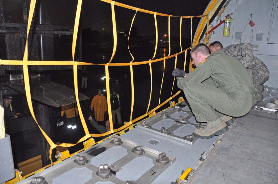 SSgt Joel Hildebrand directs a forklift driver from the door of a KC-135 Stratotanker while MSgt Johnny Pullen spots him from the ground. Both boom operators from the 63 ARS, MacDill AFB completed a humanitarian mission to Paraguay, June 30. (U.S. Air Force photo by Capt Joe Simms)