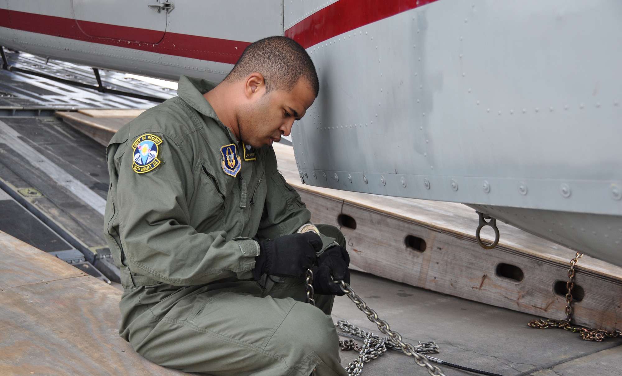 Tech. Sgt. Joe Poltor, a loadmaster with the 317th Airlift Squadron, Joing Base Charleston S.C. prepares a chain and hook assembly prior to loading a helicopter onboard a C-17 Globemaster III.  (U.S. Air Force photo by Staff Sgt. Bobby Pilch)