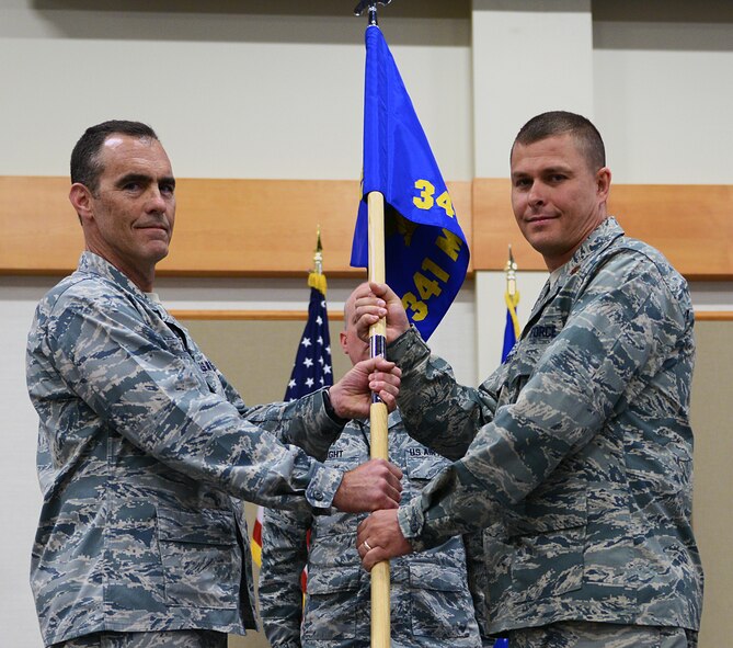 Maj. Andrew Slaughter (right), accepts command of the 341st Munitions Squadron from Col. David Lair, 341st Maintenance Group commander, at the Grizzly Bend on July 1 during a change of command ceremony. Maj. Joseph Komensky was the relinquishing commander. (U.S. Air Force photo/Senior Airman Katrina Heikkinen)