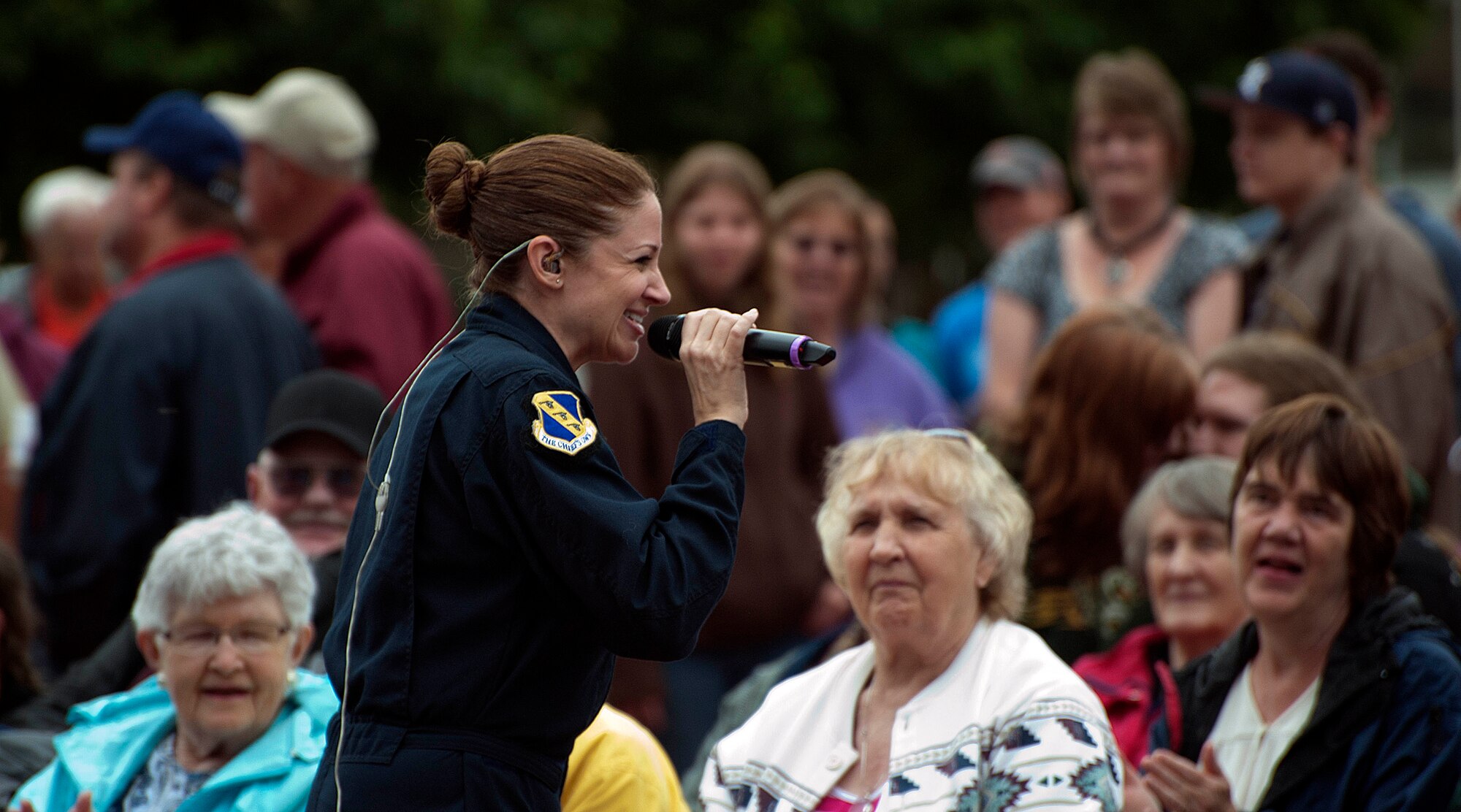 Tech. Sgt. Christin Foley, vocalist from the U.S. Air Force Band of the West, walks among the crowd as she performs a song with the U.S. Air Force band Max Impact June 27 in the Depot Square in Cheyenne, Wyo. Crowd interaction played a major role during the concert as the audience endured rainy weather for a free show. (U.S. Air Force photo by Airman 1st Class Brandon Valle)