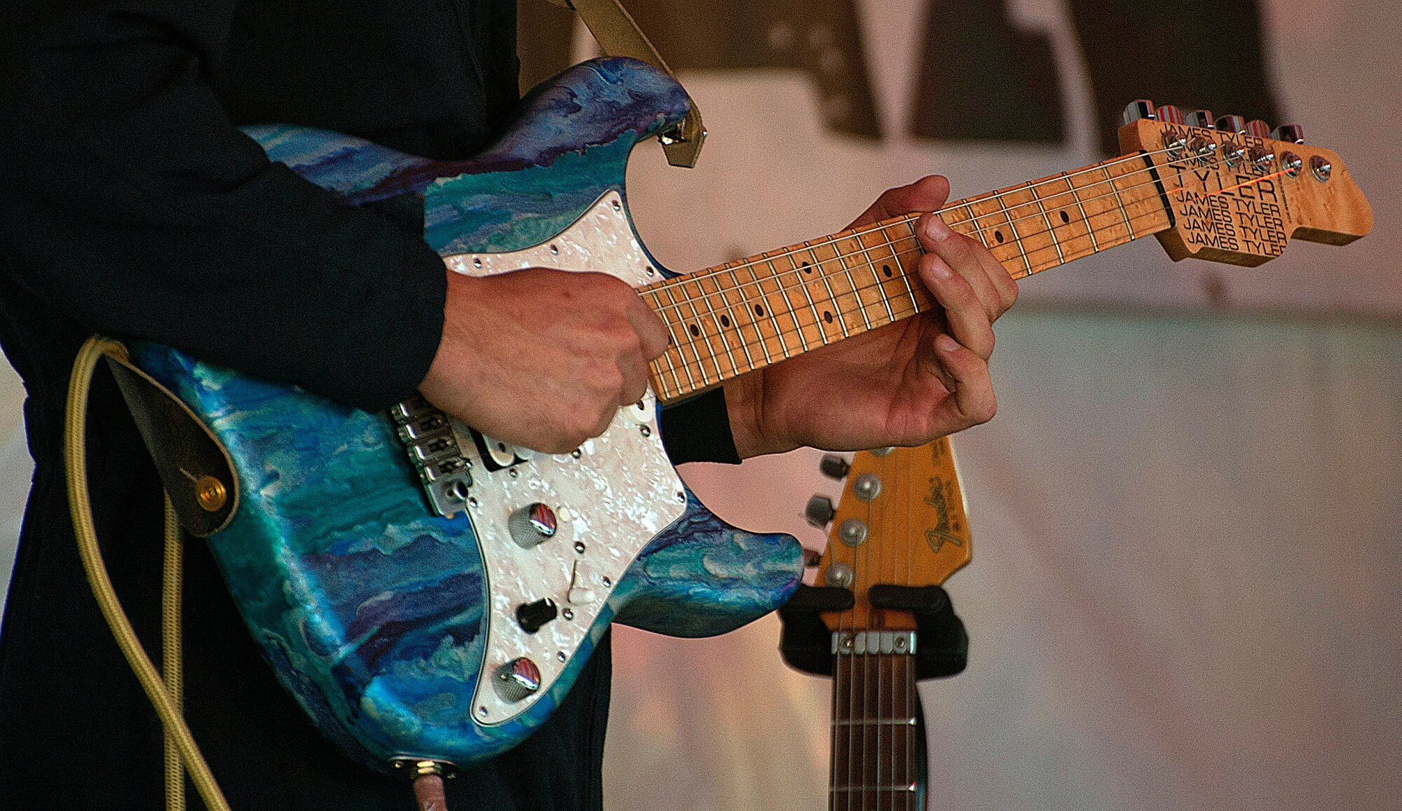 Tech. Sgt. Matthew Geist, guitarist for the U.S. Air Force band Max Impact, plays his guitar June 27 during a concert in the Depot Square in Cheyenne, Wyo. The band consists of six Airmen and three sound engineers working together to put on shows for the U.S. Air Force and the American public. (U.S. Air Force photo by Airman 1st Class Brandon Valle)