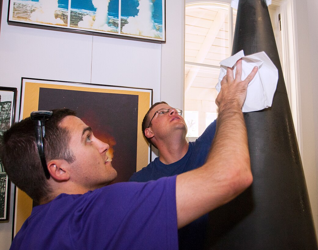 Staff Sgt. John Beier and Airman 1st Class Mark Jackson, both from the 90th Munitions Squadron, wipe down an ICBM re-entry system after being put into place on a payload support system in F.E. Warren ICBM and Heritage Museum’s Minuteman III exhibit June 20, 2014. (U.S. Air Force photo by R.J. Oriez) 