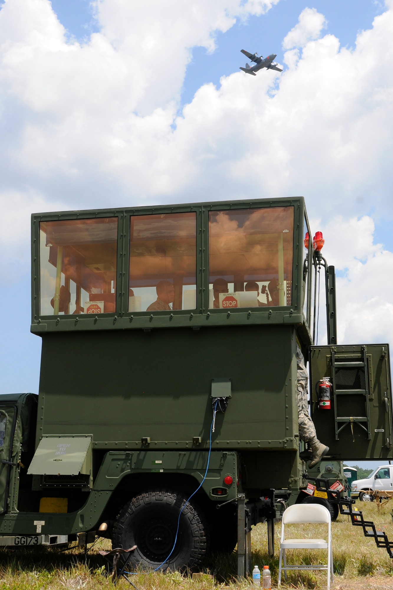 A U.S. Air Force C-130, assigned to the 145th Airlift Wing from the North Carolina Air National Guard, flies overhead as air traffic controllers from the South Carolina Air National Guard’s mobile air traffic control tower directs air traffic during a hurricane preparedness exercise at the Georgetown County Airport, S.C., June 4, 2014. South Carolina National Guard Soldiers and Airmen are working side-by-side with the S.C. Emergency Management Division and first responders from local emergency agencies, to effectively respond to any hurricane that may threaten the state. The exercise is based on a hurricane post-landfall response between federal, state and local agencies, which includes training in communications, first responder skills, with the focus on how to better protect and assist citizens during emergency situations.  (U.S. Air National Guard photo by Tech. Sgt. Jorge Intriago/Released)
