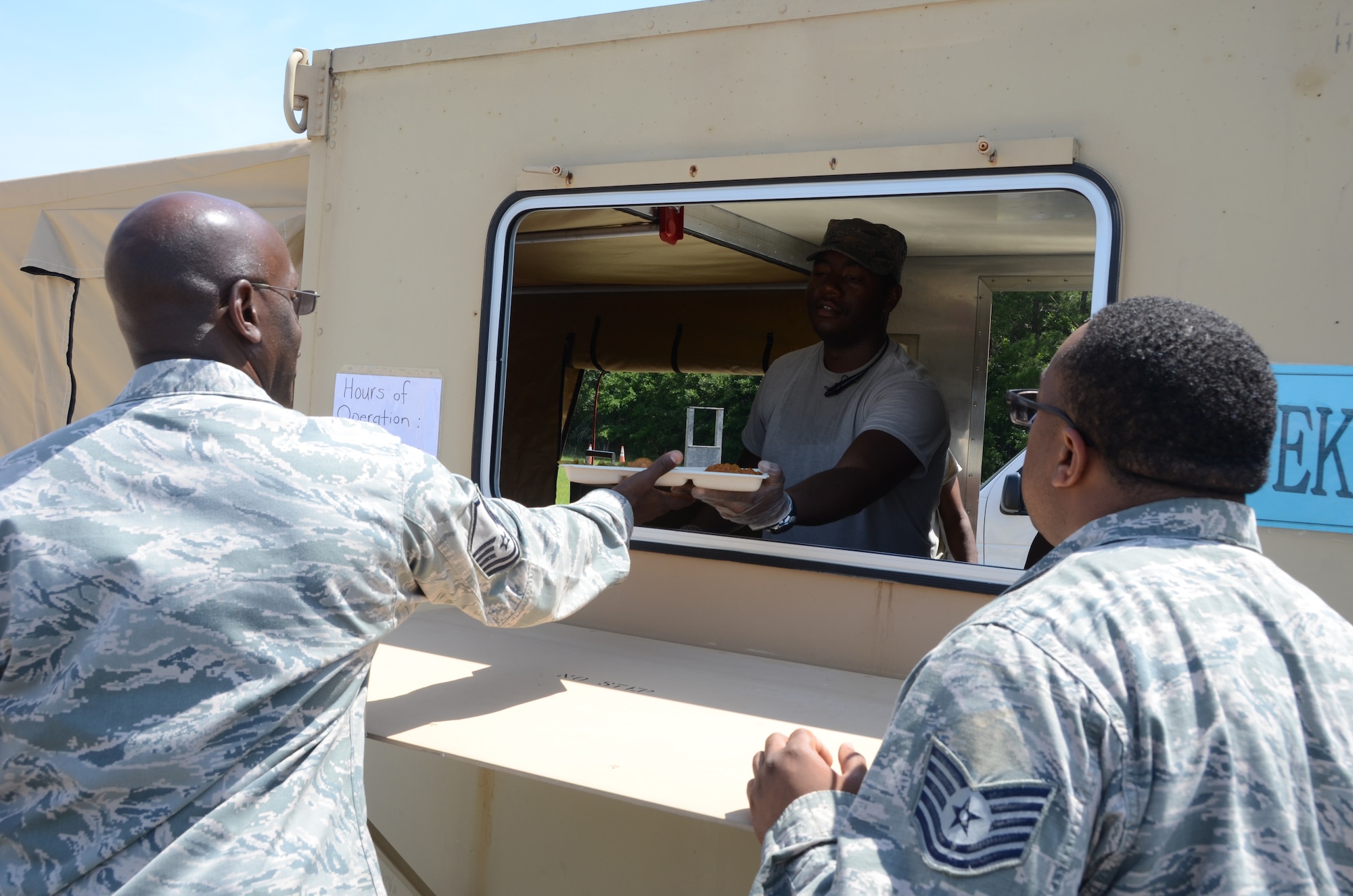 U.S. Air Force Staff Sgt. Quinten Quiinones, from the 169th Force Support Squadron from the South Carolina Air National Guard, serves a hot meal to hungry Airmen at the Georgetown County Airport, S.C., June 4, 2014. He is part of deployable team, which prepares and serves hot meals from a Single Pallet Expeditionary Kitchen. His unit is supporting a hurricane preparedness exercise as part of the Airmen who are working side-by-side with the S.C. Emergency Management Division and first responders from local emergency agencies, to effectively respond to any hurricane that may threaten the state. The exercise is based on a hurricane post-landfall response between federal, state and local agencies, which includes training in communications, first responder skills, with the focus on how to better protect and assist citizens during emergency situations. (U.S. Air National Guard photo by Senior Master Sgt. Edward Snyder/Released)