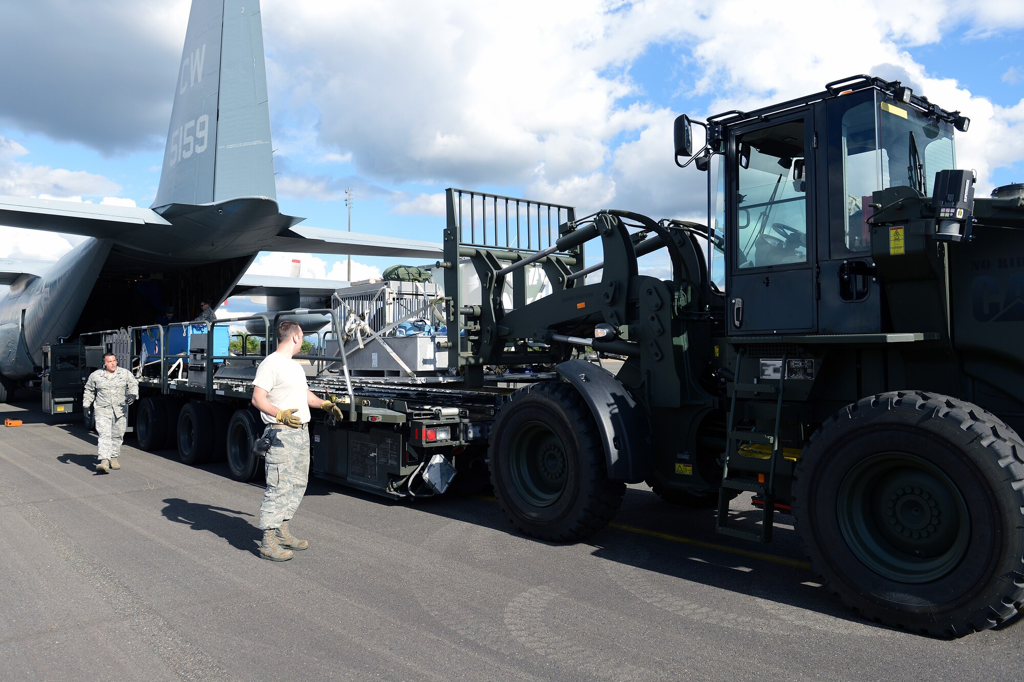 Senior Airman Randy Kraus (center), 62nd Aerial Port Squadron ramp services team chief, marshals Airman 1st Class Elishah Webb (driver), 62nd APS ramp services element member, while unloading a sea lion from a Tunner 60k loader June 24, 2014, at Joint Base Lewis-McChord, Wash. 62nd APS aerial porters assisted in the unloading and transfer of a sea lion and dolphin belonging to the Navy Marine Mammal Program after they were flown to JBLM from San Diego, Calif. (U.S. Air Force photo/Airman 1st Class Jacob Jimenez)