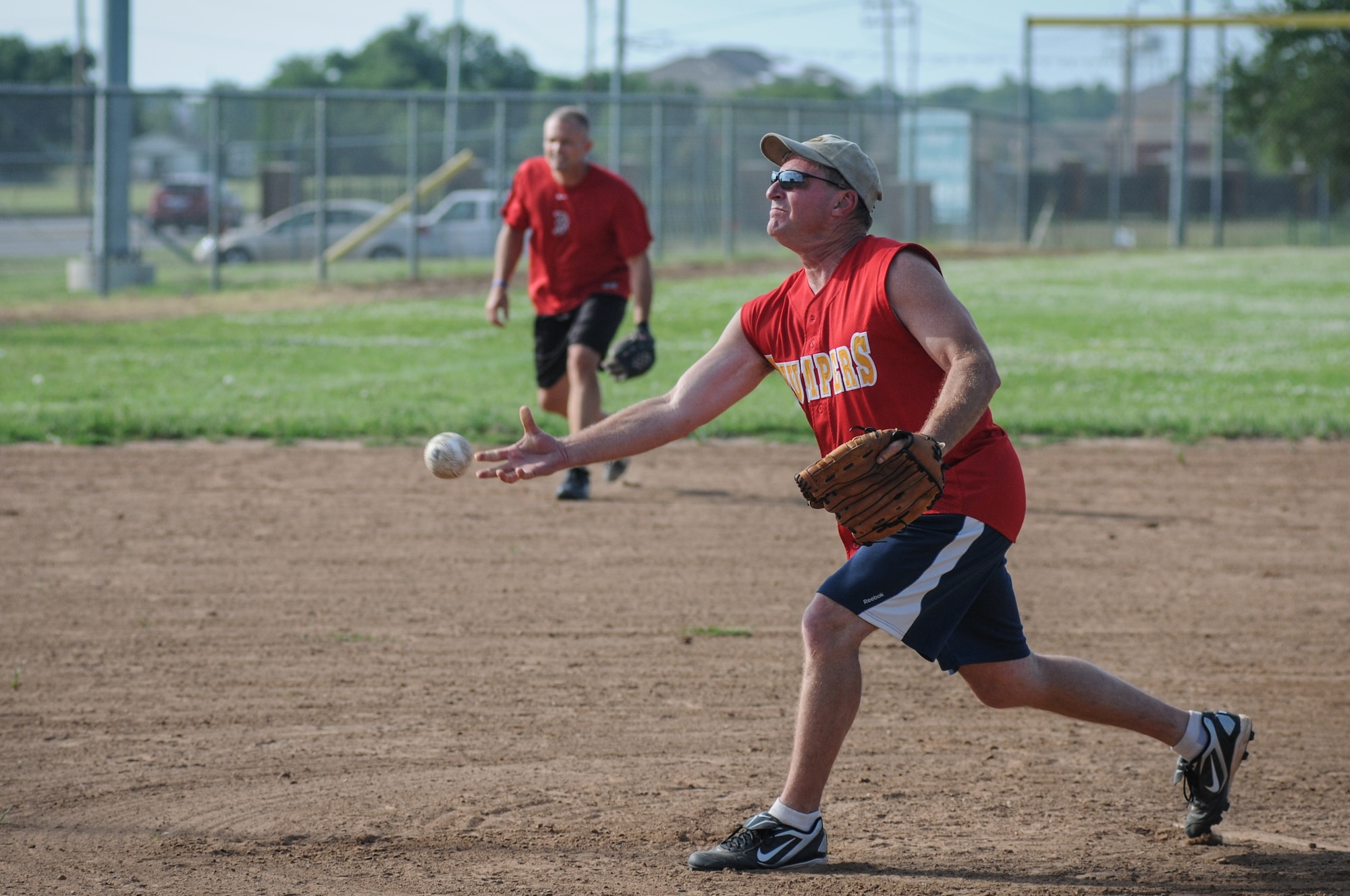 Lt. Col. Lloyd Palmer from the 513th Operations Support Squadron releases a pitch during a game against the 552nd Aircraft Maintenance Squadron Eagles on June 26 at Tinker Air Force Base, Oklahoma. Palmer was the winning pitcher for the first out of two games that night against the Eagles. (U.S. Air Force Photo/Staff Sgt. Caleb Wanzer)