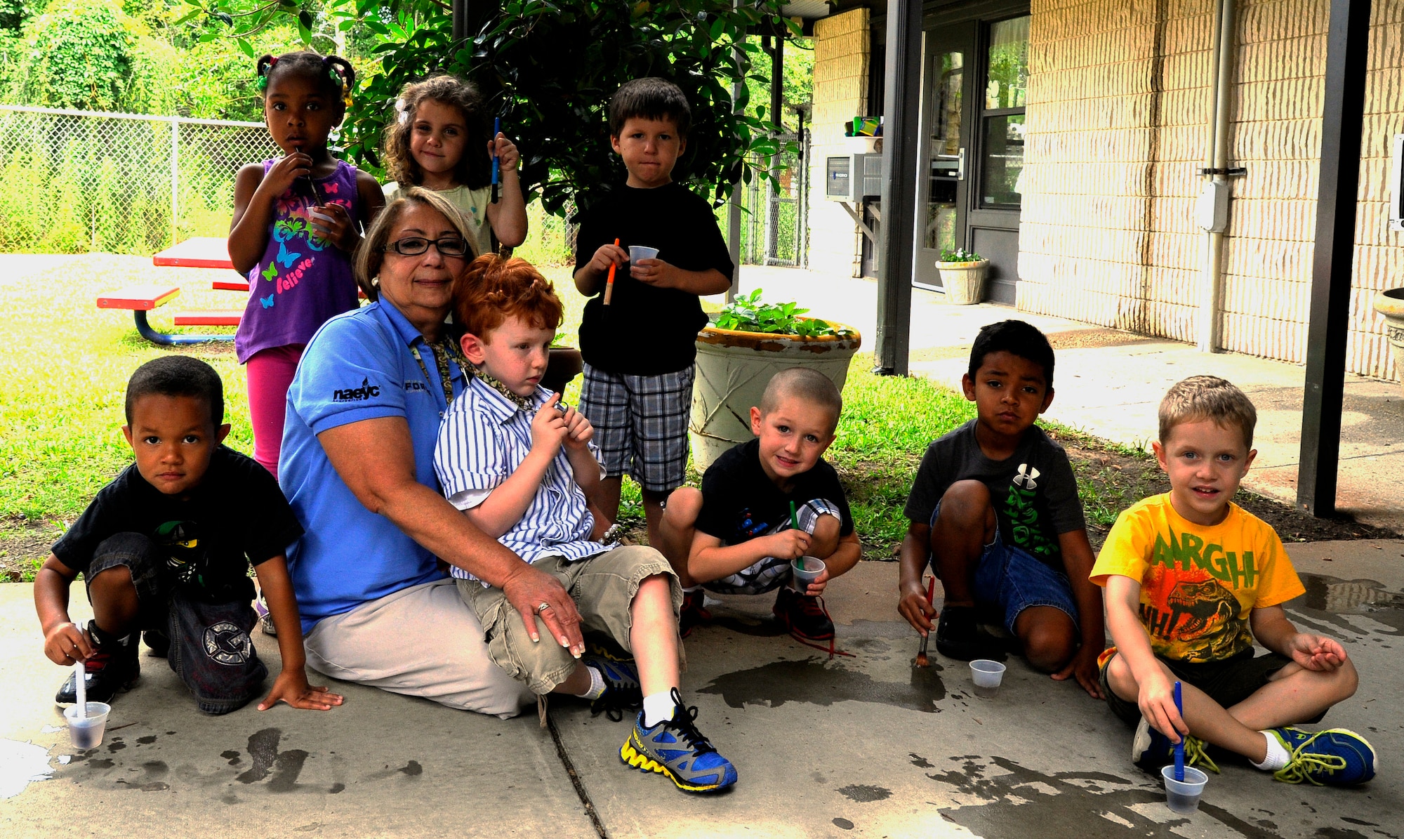Nora Torres, preschool teacher, sits with her class during an outside activity at the main child development center on Hurlburt Field, Fla., June 25, 2014. Torres has worked at the CDC since 1985. (U.S. Air Force photo/Staff Sgt. Sarah Hanson)
