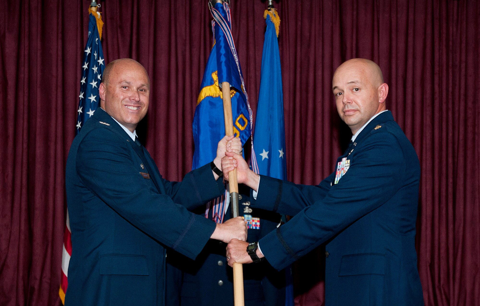 Col. Travis Condon, 90th Mission Support Group commander, passes the 90th Communications Squadron guidon to Maj. David Sorrels as he assumes command of the squadron during a change-of-command ceremony July 26 in the Trail’s End Club on F.E. Warren Air Force Base, Wyo. (U.S. Air Force photo by Airman Malcolm Mayfield)