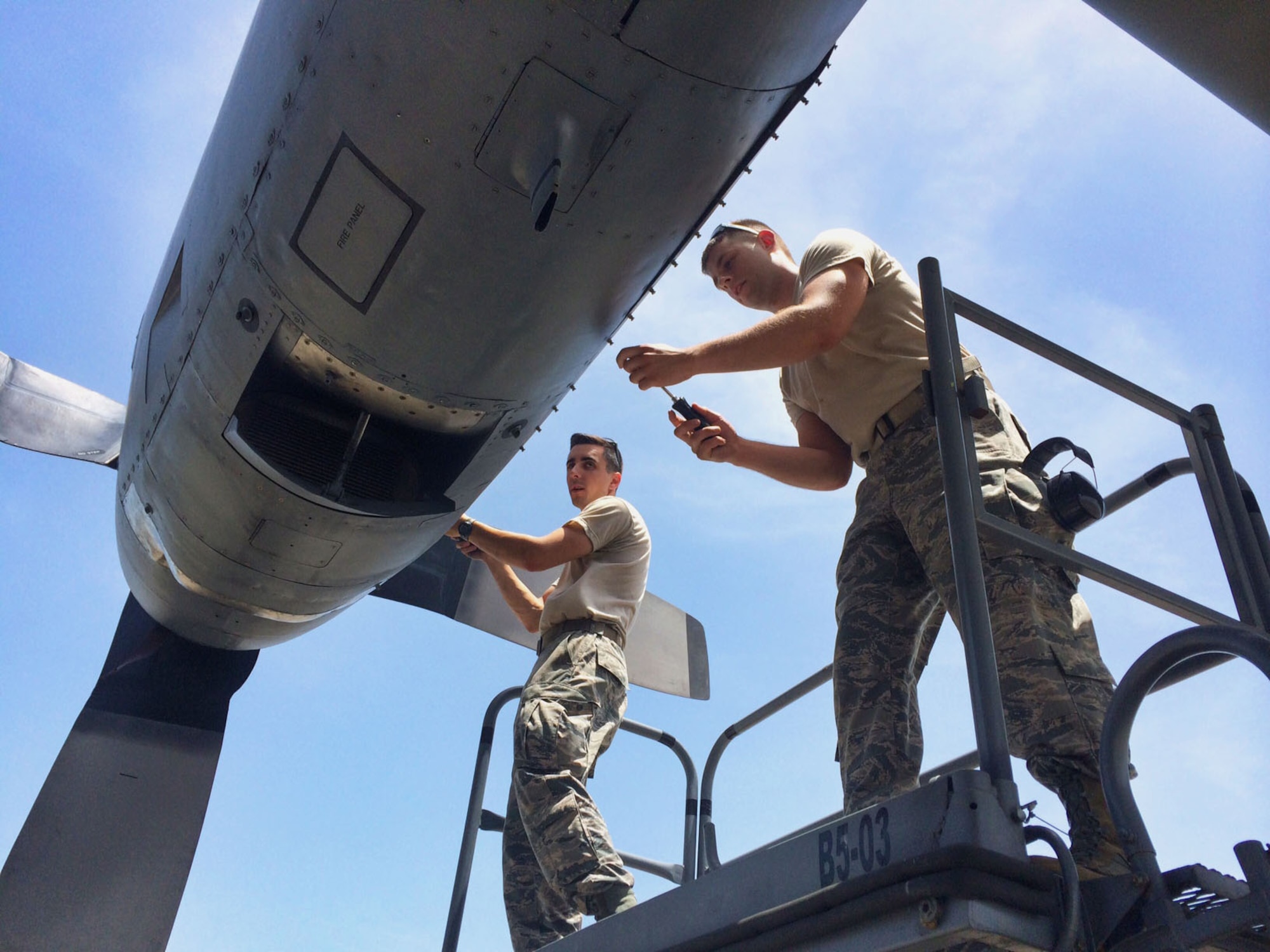 Staff Sgt. Vincenzo Lafronza (left), with the 123rd Maintenance Group, Kentucky Air National Guard, and Senior Airman Steven Maniscalco (right), with the 103rd Maintenance Squadron, Connecticut Air National Guard, fasten cam locks after closing an access panel on the C-130H aircraft at the Combat Readiness Training center, Gulfport, Miss., June 24, 2014. Inspecting access panels is part of the basic post flight inspection in which Kentucky and Connecticut maintenance Airmen are receiving training. (U.S. Air National Guard photo by Senior Airman Jennifer Pierce)