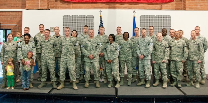New technical sergeant selects pose with Col. Tracey Hayes, 90th Missile Wing commander, and Chief Master Sgt. Samuel Couch, 90th MW command chief, in the Fall Hall Community Center June 27, 2014. Achieving the rank of technical sergeant is considered notoriously difficult among enlisted Airmen. 42 Airmen were chosen from the 20th Air Force and the 90th MW. (U.S. Air Force photo by Airman 1st Class Jason Wiese)