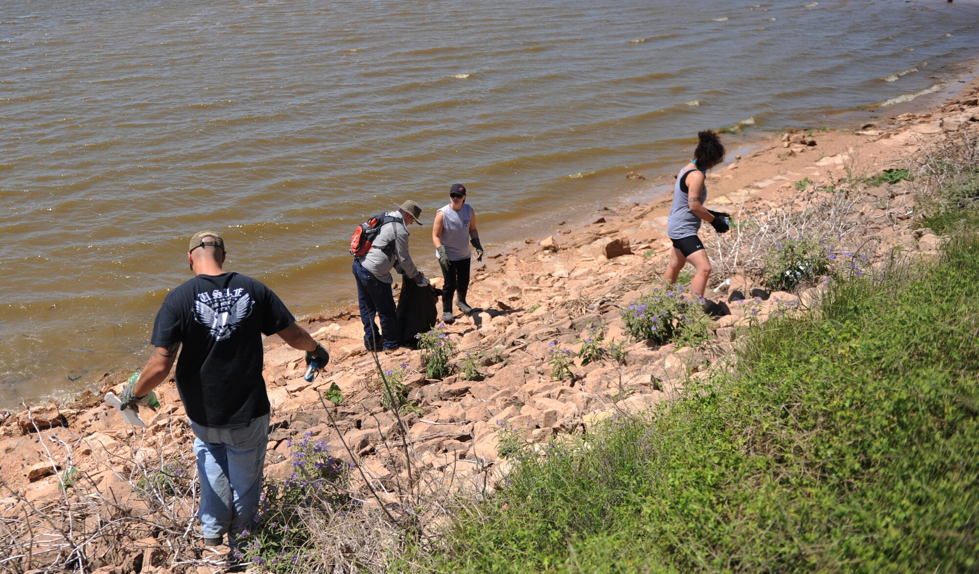 U.S. Air Force Airmen and family members from Dyess Air Force Base walk along Kirby Lake’s banks removing trash, June 14, 2014, Abilene, Texas. The Dyess volunteers worked in conjunction with the Keep Abilene Beautiful organization to help remove garbage from around the lake. (U.S. Air Force photo by Airman 1st Class Alexander Guerrero/Released)
