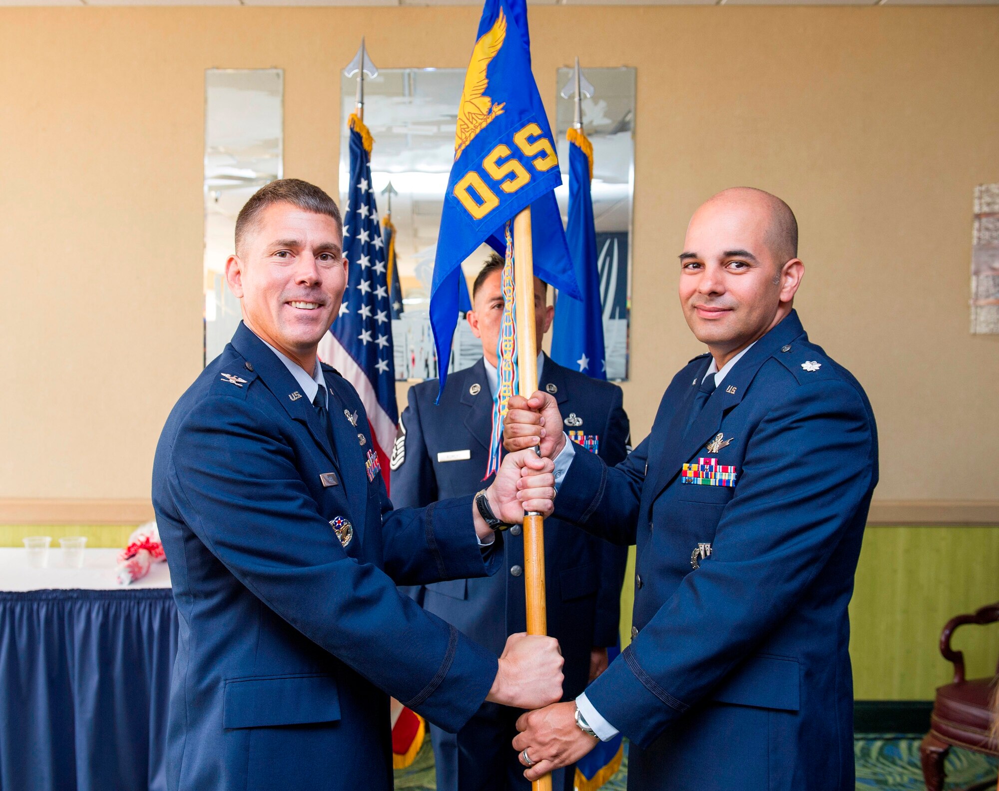 Col. Robert Quigg IV, 45th Operations Group commander, presents Lt. Col. Raymundo Tulier, 45th Operations Support Squadron commander, with the 45th OSS guidon during a change of command ceremony June 27, 2014, at Patrick Air Force Base, Fla. Changes of command are a military tradition representing the transfer of responsibilities from the presiding officials to the upcoming official. (U.S. Air Force photo/Matthew Jurgens)