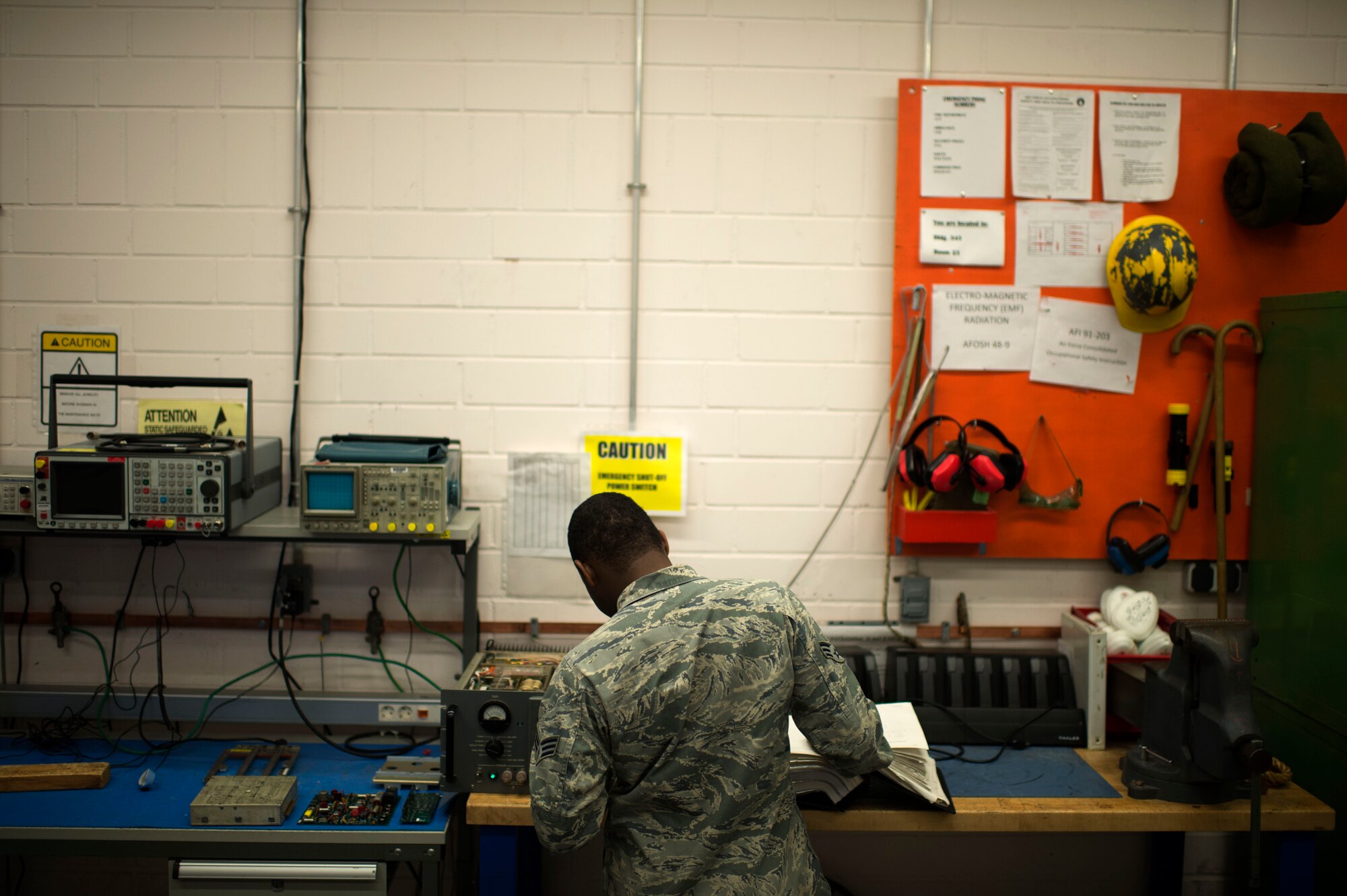 U.S. Air Force Senior Airman Jaquan Stewart, 606th Air Control Squadron radio frequency transmission technician from Folkston, Ga., troubleshoots a GRC-171 radio transceiver at Spangdahlem Air Base, Germany, June 30, 2014. Stewart uses an electrostatic discharge mat while touching the equipment to ground himself and mitigate any risk of electrical damage to the radio. (U.S. Air Force photo by Senior Airman Gustavo Castillo/Released) 