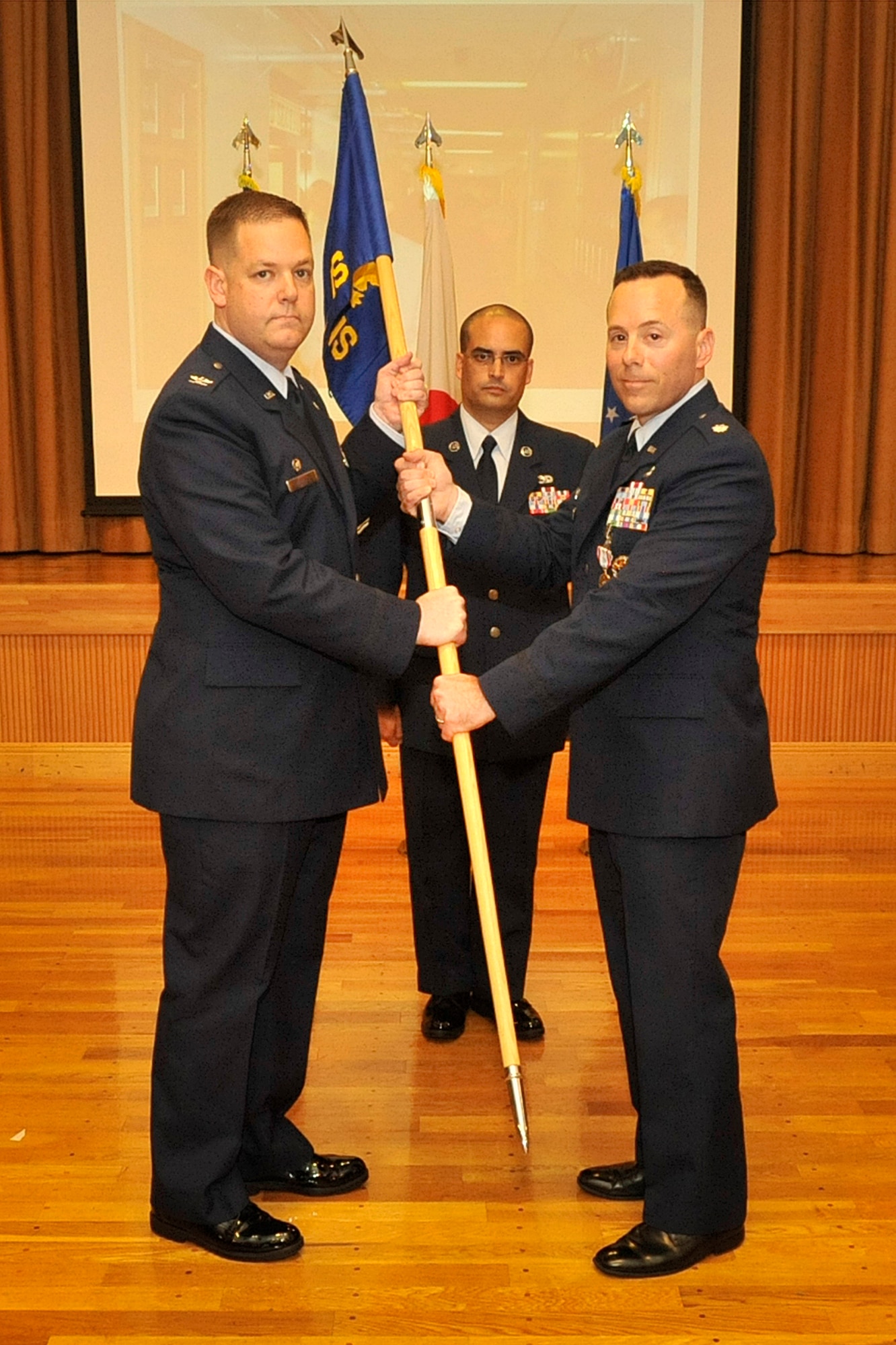 U.S. Air Force Col. Michael Winters, 373rd Intelligence, Surveillance and Reconnaissance commander, left, receives the guidon from U.S. Air Force Lt. Col. Eric Monico, 301st Intelligence Squadron commander, during an inactivation ceremony at Misawa Air Base, Japan, June 30, 2014. The 301 IS will relocate to Joint-Base Elmendorf Richardson, Alaska on July 2, 2014. (U.S. Air Force photo/ Staff Sgt. Tong Duong)