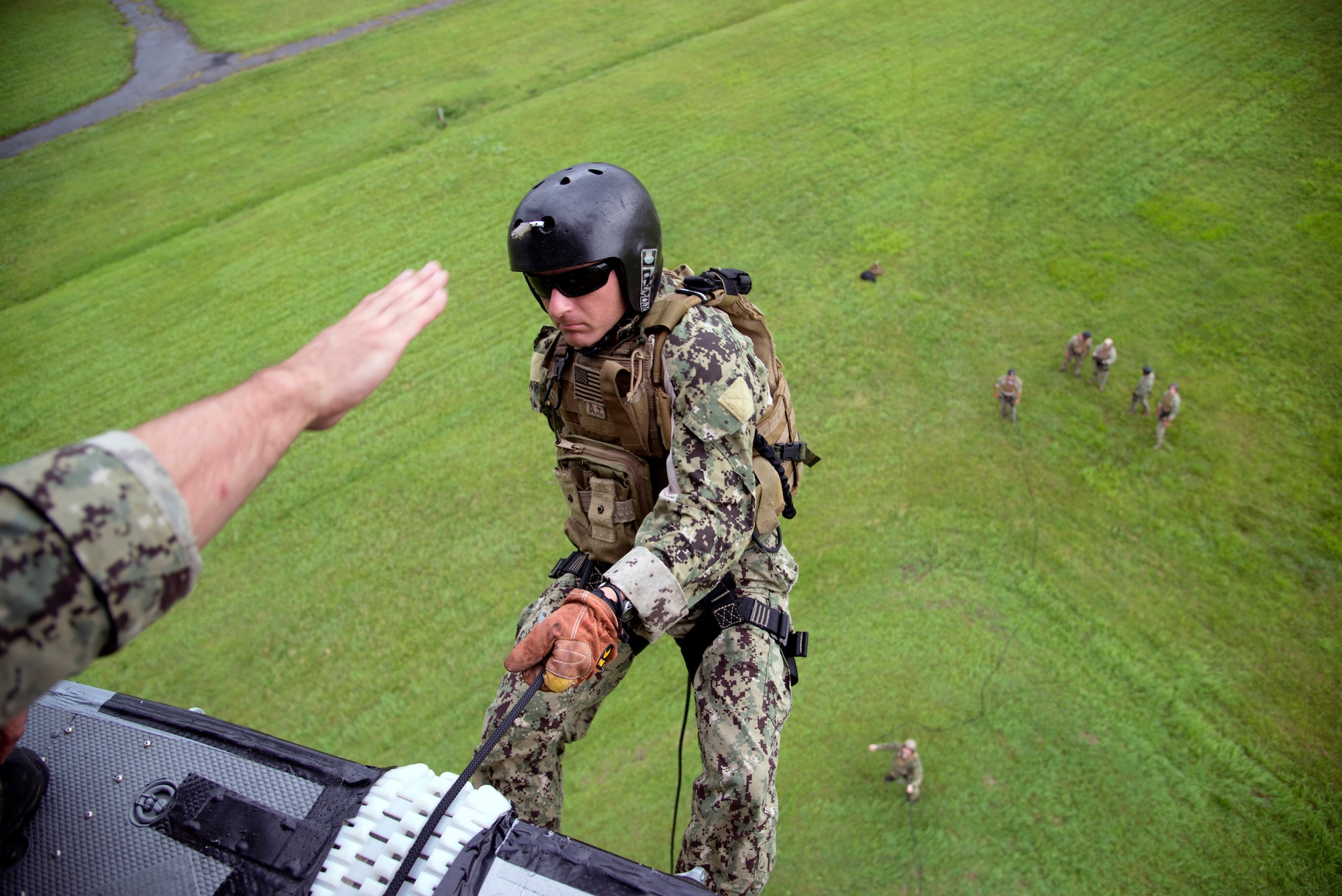U.S. Navy Explosive Ordnance Disposal Technician 1st Class Joseph Hawley gives the “go” command before EOD Technician Senior Chief Mark Morgan rappels from a UH-1N Huey June 25, 2014 at Yokota Air Base, Japan.  Navy EOD assigned to EOD Mobile Unit 5, Yokosuka Naval Base, Japan, practice rappelling to stay qualified for real-world contingencies. (U.S. Air Force photo by Tech Sgt. Melissa K. Mekpongsatorn/Released)
