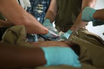 Members of a Forward Resuscitative Surgical System team with 2nd Medical Battalion, 2nd Marine Logistics Group tend to a simulated casualty during the Pre-Deployment Trauma Training Course at Camp Lejeune, N.C., June 28, 2014.  Dummies and actors were used as patients in the training to closely simulate a mass casualty scenario. 