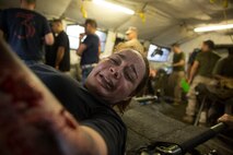 Lt. Regina Johnson, a chaplain with 2nd Medical Battalion, 2nd Marine Logistics Group, plays the role of a simulated casualty with neck and arm wounds during pre-deployment training at Camp Lejeune, N.C, June 28, 2014. Several role players helped provide a more realistic environment during training for medical personnel as they responded to a simulated mass casualty scenario.