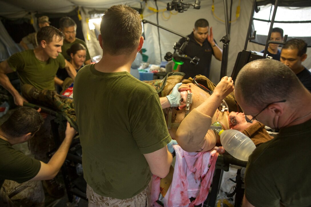 Members of the Forward Resuscitative Surgical System team, 2nd Medical Battalion, 2nd Marine Logistics Group, carry a simulated casualty into the operating room during pre-deployment training at Camp Lejeune, N.C, June 28, 2014.  The training tested the team’s ability to work together under pressure and provided realistic training scenarios.