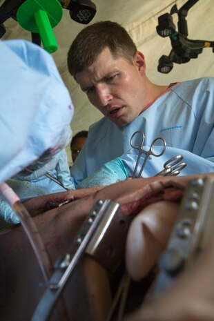 Lt. Cmdr. Ben Davis, a surgeon on a Forward Resuscitative Surgical System team with 2nd Medical Battalion, 2nd Marine Logistics Group, operates on a simulated casualty during pre-deployment training at Camp Lejeune, N.C., June 28, 2014. Davis worked with several other members of the FRSS team in the operating room to prepare for real-life scenarios and hone the team’s sense of cohesion.
