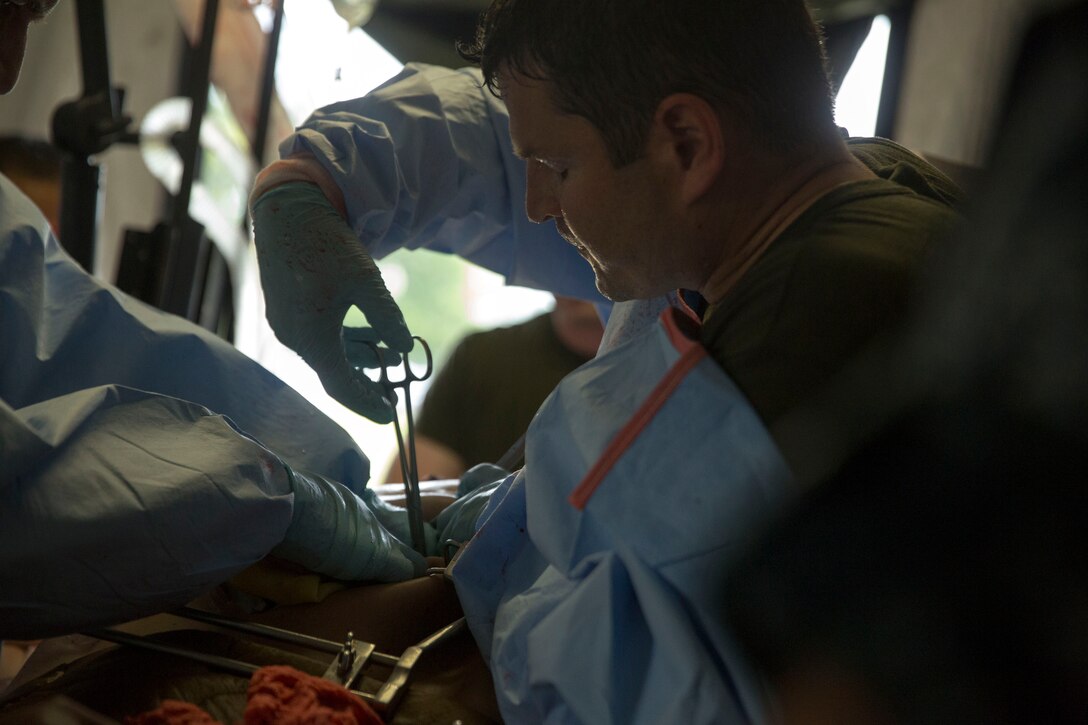 Lt. Cmdr. Joseph Fitzpatrick, a Forward Resuscitative Surgical System team member with 2nd Medical Battalion, 2nd Marine Logistics Group treats a simulated casualty wearing a CutSuit, a hyper-realistic surgical simulator that mimics the inside and outside of the human body, during a training scenario at Camp Lejeune, N.C, June 28, 2014. Service members with mock injuries helped increase the realism of the training as the unit prepared for possible casualty scenarios.  

