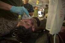 A Forward Resuscitative Surgical System team with 2nd Medical Battalion, 2nd Marine Logistics Group, assist a simulated casualty during a training scenario at Camp Lejeune, N.C, June 28, 2014. Service members with mock injuries helped increase the realism of the training as the team prepared for its coming deployment.  