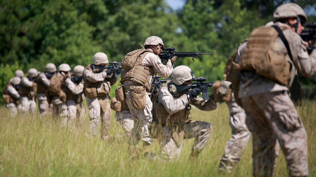 Corporal Desmond Albarracinahana (center), 21, a combat engineer with Engineer Company, Marine Wing Support Squadron 273, Marine Aircraft Group 31, and native of Ewa Beach, Hawaii, conducts small-arms fire exercises during a field exercise aboard Army base, Ft. Stewart, Ga., June 25. Combat Engineers build, repair and maintain buildings, roads and power supplies while employing explosives for construction and demolition projects. MWSS-273 provides all essential aviation ground support to a designated fixed-wing component of a Marine Aviation Combat Element to include internal airfield communications, weather services, expeditionary airfield services, aircraft rescue and firefighting, aircraft and ground refueling, essential engineering services, motor transport, messing, chemical defense, security and law enforcement, airbase commandant functions, and explosive ordinance disposal.