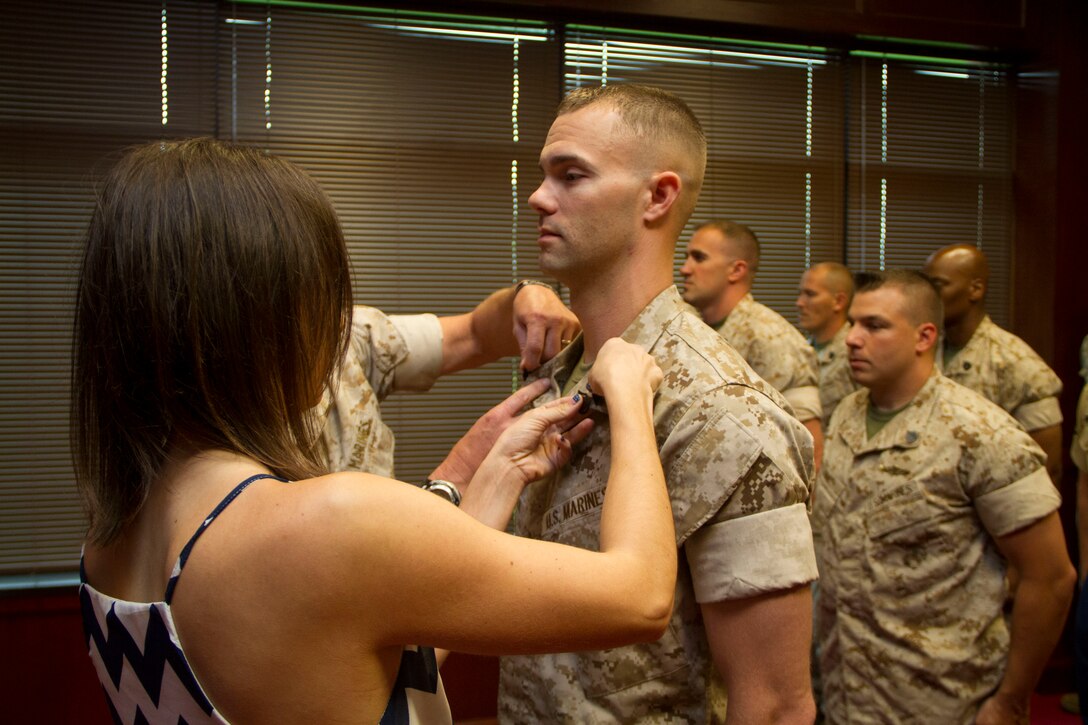 Kerry Johnsen pins the rank of Staff Sergeant on her husband, Staff Sgt. Nicholas C. Johnsen, during a meritorious promotion ceremony at the Military Entrance Processing Station in Milwaukee, Wis., July 2, 2014.  Staff Sgt. Johnsen was the 9th Marine Corps District’s Officer Selection Assistant of the year for fiscal year 2013.