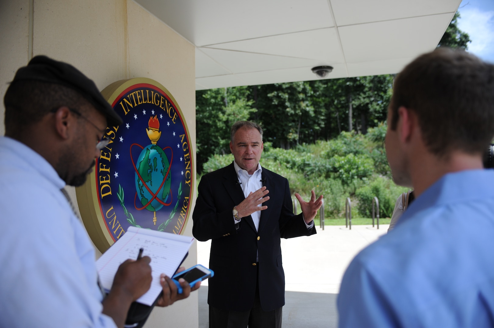 Sen. Tim Kaine talks with reporters outside of DIA’s Col. James N. Rowe building in Charlottesville, Va., July 1. 