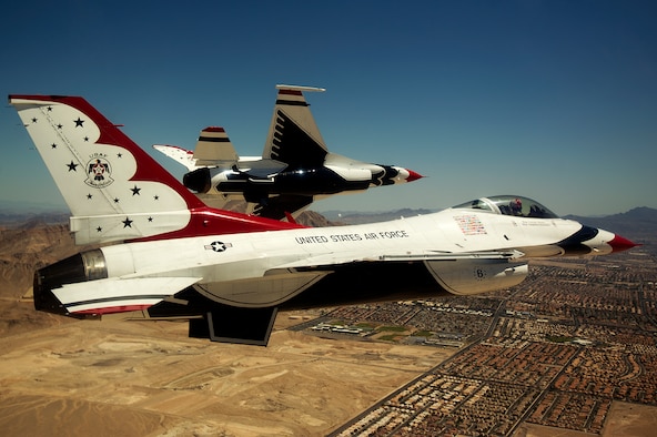 Maj. Blaine Jones, Thunderbird 5 and lead solo, pitches to land as Maj. Jason Curtis, Thunderbird 6 and opposing solo, waits clearance for his pitch to land June 30, 2014, upon returning from a practice demonstration sortie at Nellis Air Force Base, Nev. The Thunderbirds, flying red, white and blue F-16 Fighting Falcons, are the Air Force’s precision flying demonstration team. (U.S. Air Force photo/Staff Sgt. Larry E. Reid Jr.)