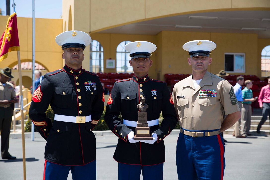 Sgt. Matthew S.Earle, left, recruiter, from Marine Corps Recruiting San Mateo, CA, Lance Cpl. Lawrence Liechty, middle, Company F Honorman, and Sgt. Maj. Larry Liechty, right, sergeant major, RS San Francisco, stand for a photo after graduation aboard Marine Corps Recruit Depot San Diego, June 13, 2014. Lance Cpl. Liechty graduated bootcamp as the Company F Honorman, a title only one Marine from each cycle can earn.