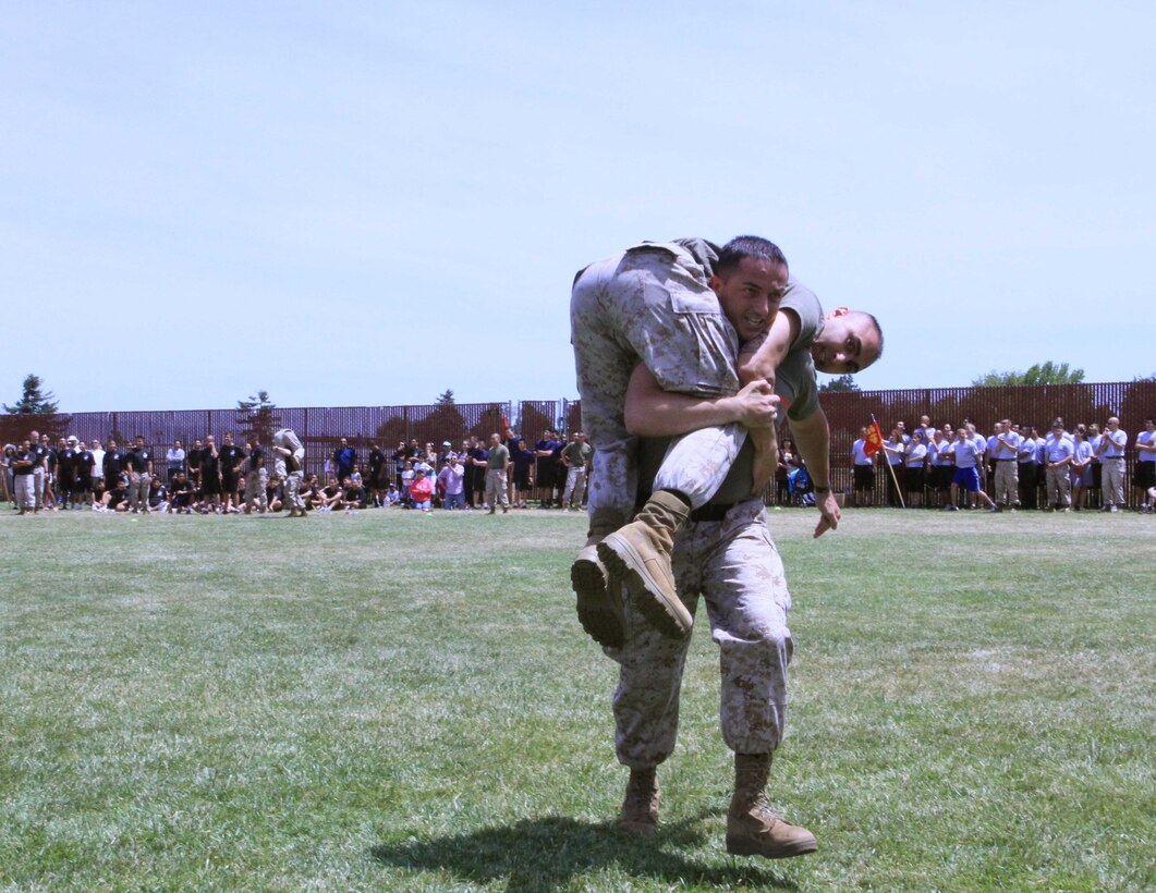 Recruiting Station San Francisco Marines conduct a fireman's carry competition during the RS' Poolee Family Day aboard Moffett Airfield, May 17, 2014. The Poolee Family Day brought together over 300 poolees and their families, to strengthen the relationships between them and Marines. The poolees participated in a cadence run, field competitions, and were introduced to a few drill instructors throughout the course of the day.