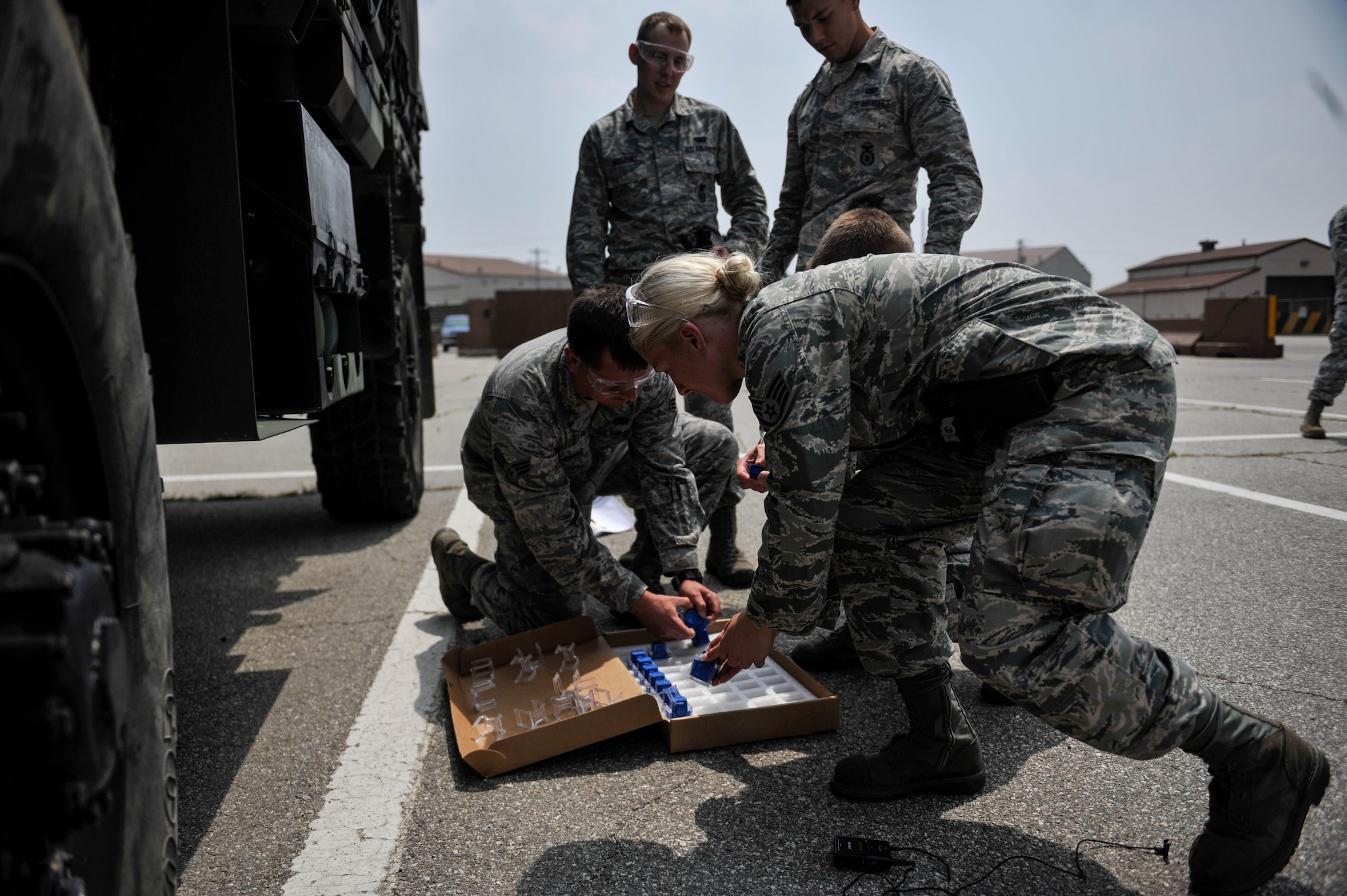 Airmen from the 51st Security Forces Squadron pick up cartridges during Taser training on Osan Air Base, Republic of Korea, June 27, 2014. Airmen must go through Taser International training, pass a written test and be able to effectively engage a target with a minimum of two Taser cartridges before they can carry a Taser. (U.S. Air Force photo/Senior Airman David Owsianka)