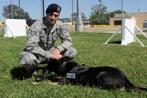 Staff Sgt. Nicholas Frustaci, 9th Security Forces Squadron military working dog handler, pets Dingo after running through the obedience course June 17, 2014, at Beale Air Force Base, Calif. Dingo and Frustaci have been assigned together since September 2013. (U.S. Air Force photo by Airman 1st Class Ramon A. Adelan/ released) 